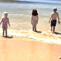 three children walking into the sea, symbolising calm and connection